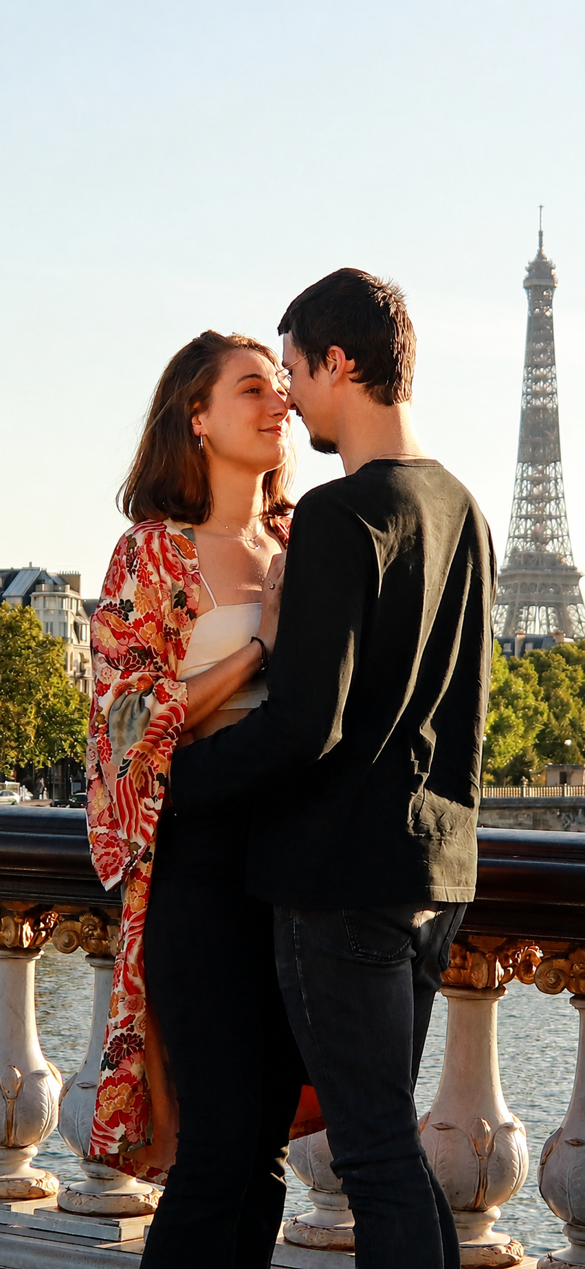 Un couple sur un pont à Paris, la tour Eiffel en arrière-plan